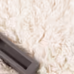 Vacuum attachment cleaning a white shag rug