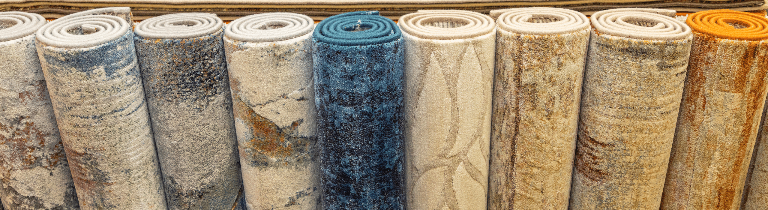 Several accent rugs rolled up and standing upright in a row