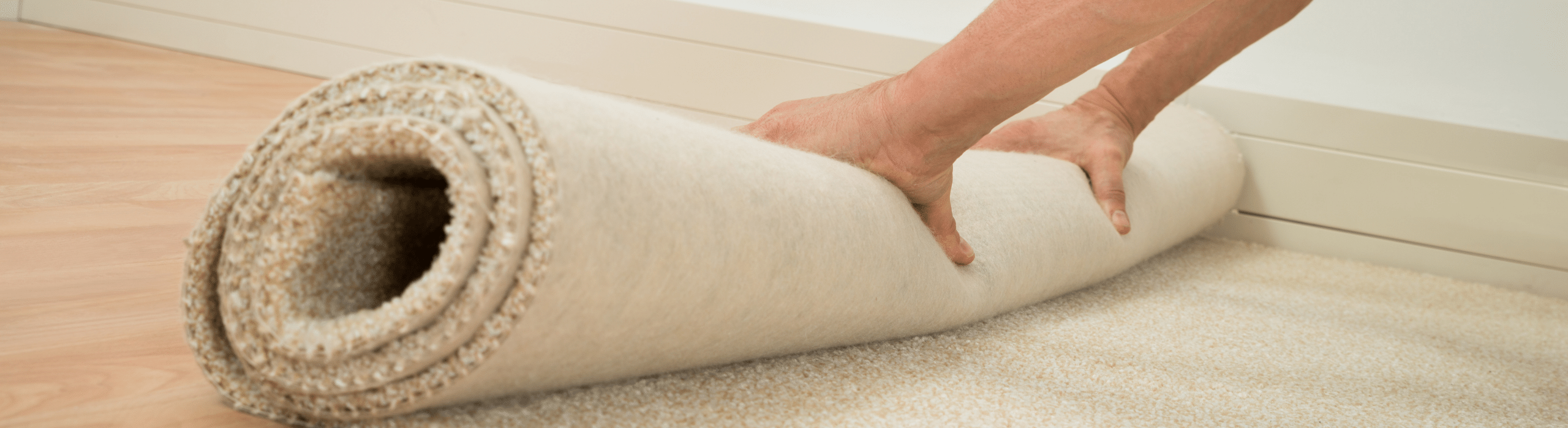 Person rolling out carpet during DIY carpet installation