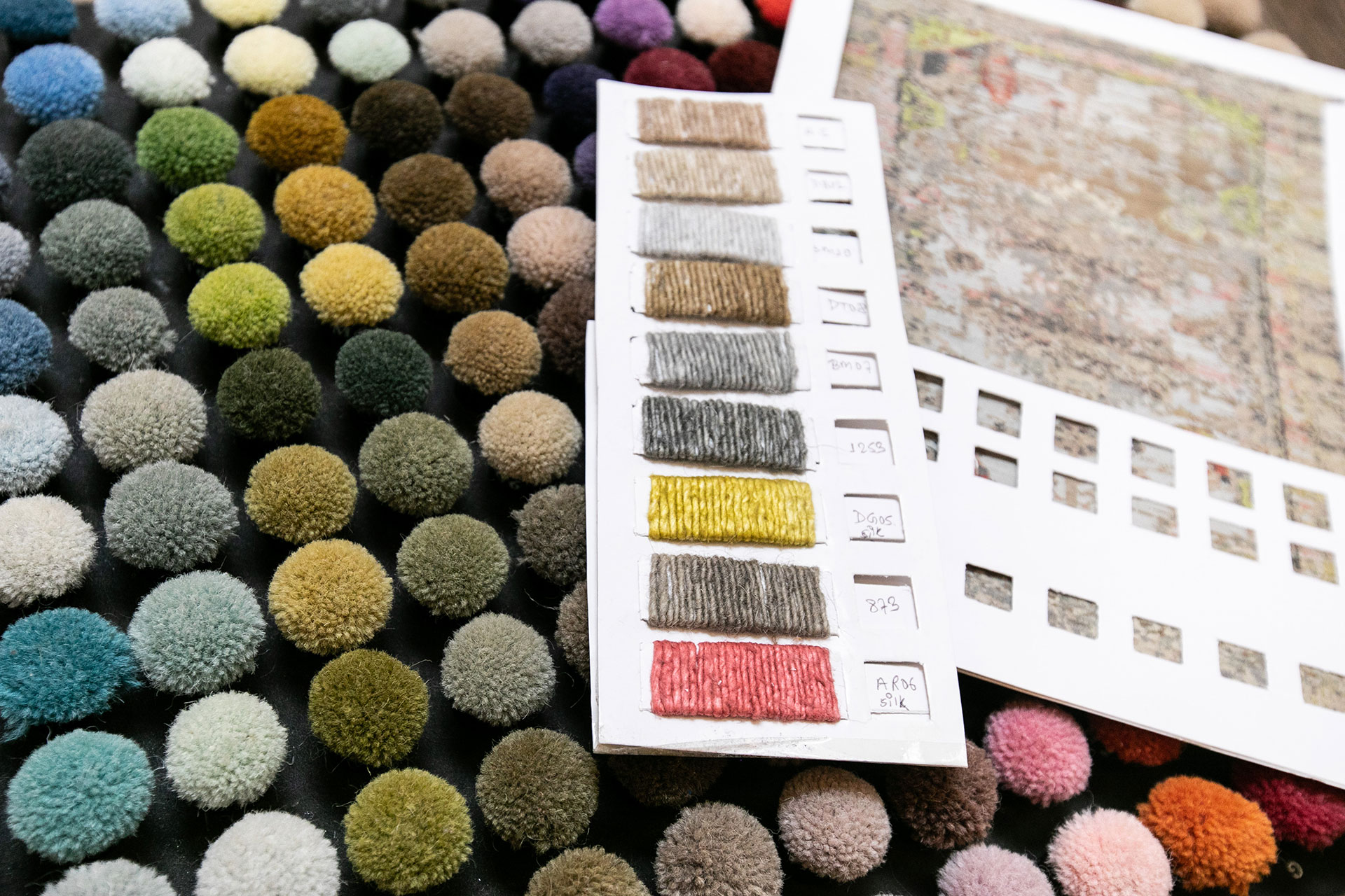Colorful yarn samples and sample book showing custom rug options