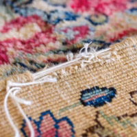 Closeup of raveling on an Oriental rug in need of repair