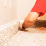 Professional carpet installation being done in home with beige carpet