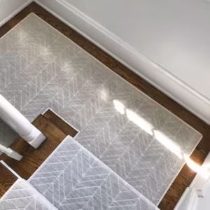 Gray and white stair runner installed on brown wooden staircase in Cincinnati, Ohio