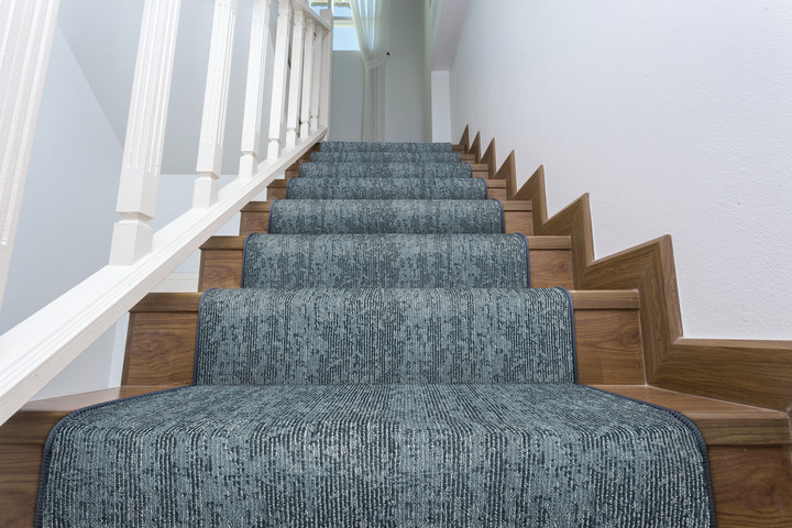 Photo of blue custom stair runners from the rug gallery placed on dark wood stairs