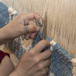 Woman hand-knotting a Persian rug