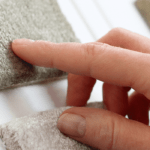 Closeup of hand touching different types of carpet samples