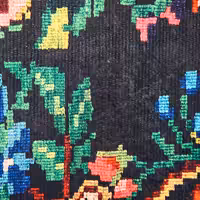 Floral needlepoint design on gray rug showing loss of shape