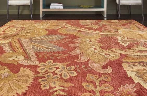 A close up a red rug with a floral pattern