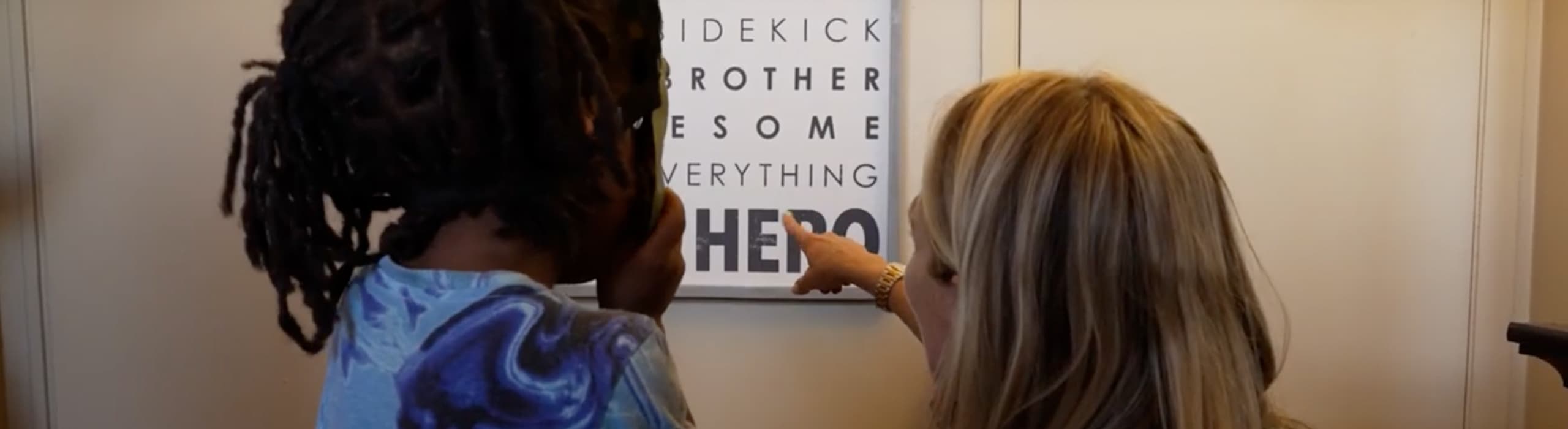 A women point to a sign with a kid