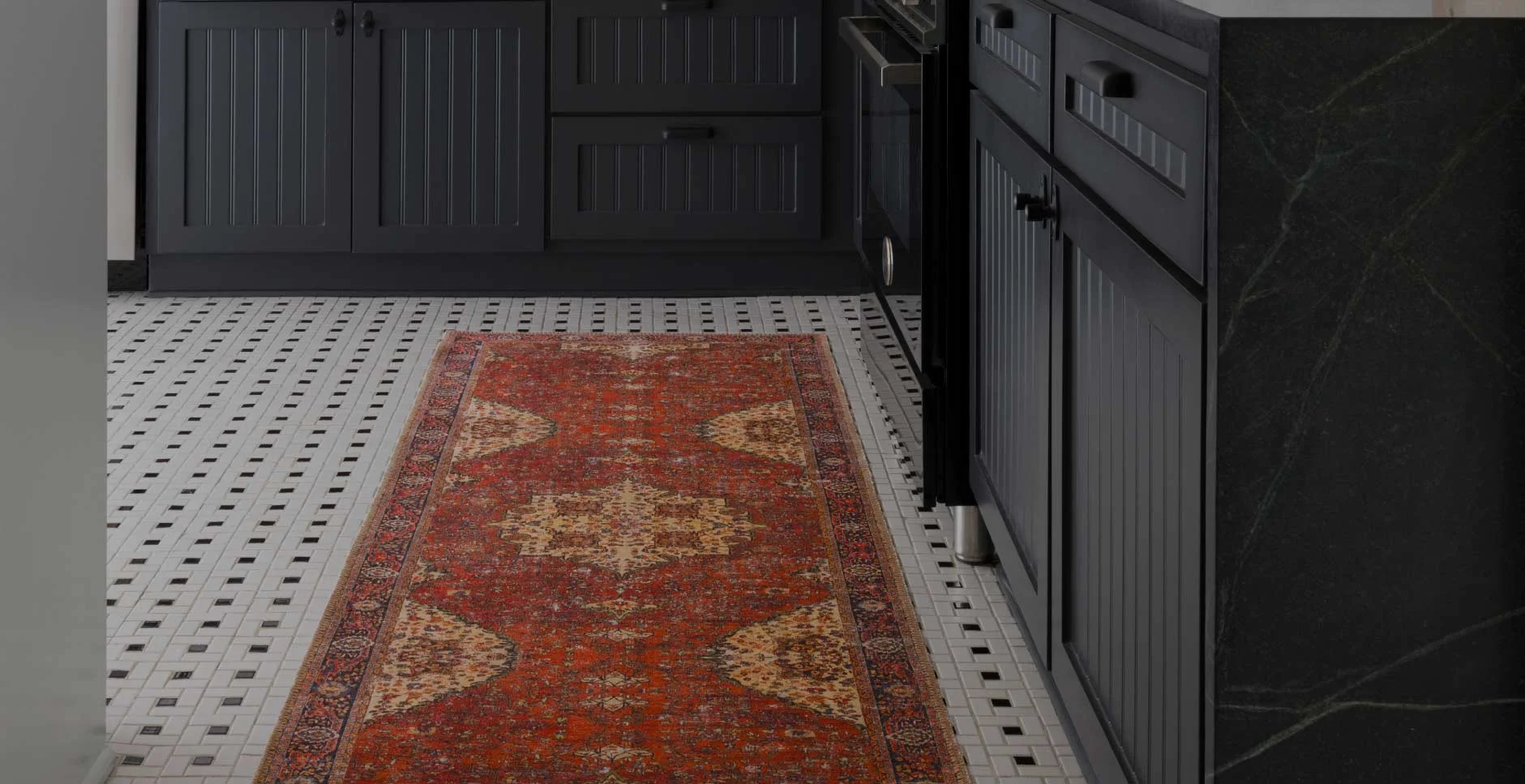 A kitchen with a red rug